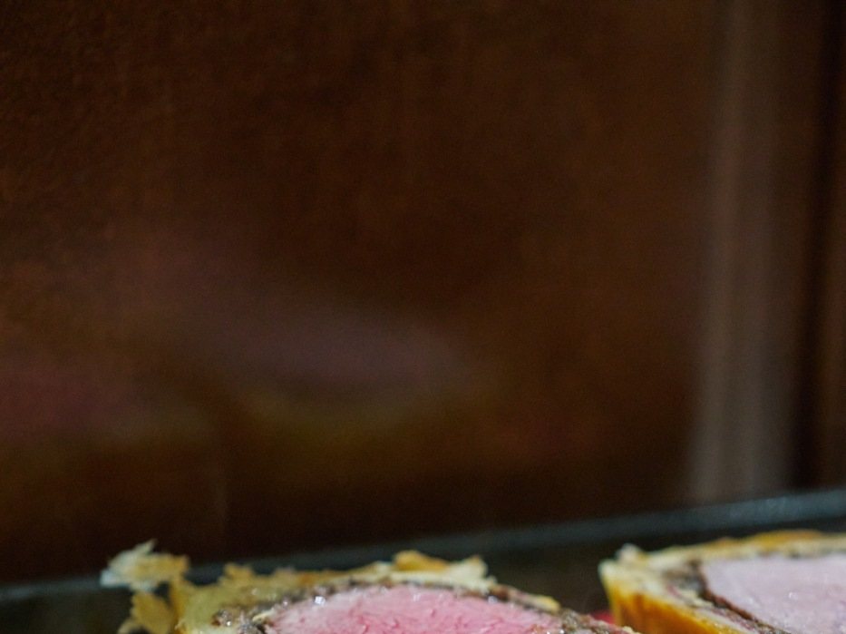 Beef wellington sliced to show the pink centre in its pastry case